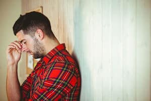 handsome hipster feeling stressed out on wooden background